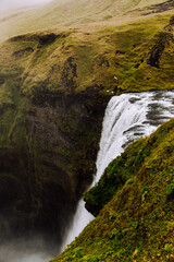 grand, epic waterfall in iceland between rock formations