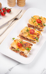 Lasagna cut into portions served on a white dish