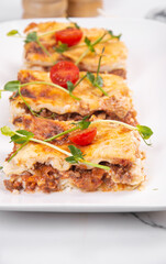 Lasagna cut into portions served on a white dish