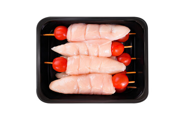 Raw chicken skewers.Raw chicken inner on skewers with tomatoes in a tray on a white...