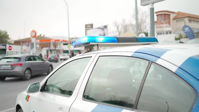 Police patrol car with flashing lights blocked the road. Close up flashing police signal lights roof of white police car.