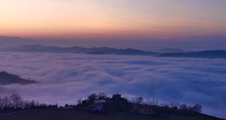 Valle inondata da un mare di nebbia e nuvole