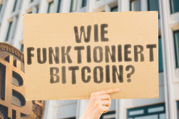 The question " How does Bitcoin work? " is on a banner in men's hands with blurred background. Technology. Finance. Money. Economic. System. Internet. Data. Security. Anonymity. Transparency. Node