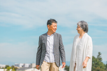 街を話しながら歩く日本人の高齢者夫婦（シニア・男女）
