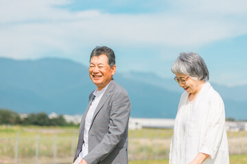 街を話しながら歩く日本人の高齢者夫婦（シニア・男女）

