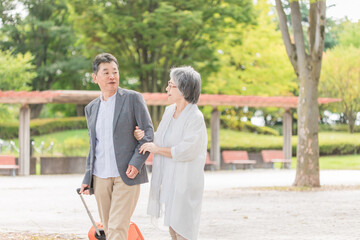 Obraz premium スーツケースを持って旅行する高齢者夫婦 