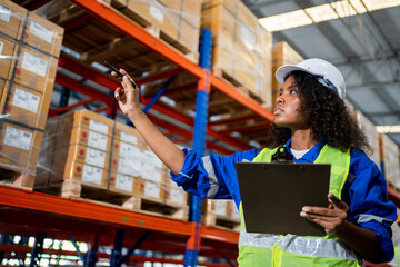 Happy Professional woman Worker Wearing Safety Vest and Hard Hat Smiling on Camera. In the Background Big Warehouse with Shelves full of Delivery Goods.