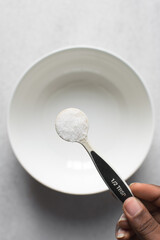 Fototapeta na wymiar Top view of a spoon of white sugar, granulated sugar for baking, a half teaspoon of sugar