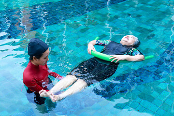 Asian woman or physiotherapist helping elderly female patient with hydrotherapy It is a rehabilitation and exercise in the water. physical therapy center - obrazy, fototapety, plakaty