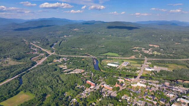 Plymouth State University and Pemigewasset River aerial view with White Mountain National Forest at the background in summer in historic town center of Plymouth, New Hampshire NH, USA. 