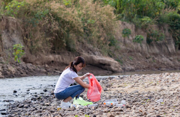 Global warming and environmental concern, Asian beautiful woman in casual collects the garbage plastic bottles in park area for recycle, girls volunteer concerns with environmentally conscious charity