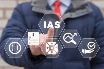 Accountant using virtual touch screen presses abbreviation: IAS. Concept of IAS International Accounting Standards. Financial statements.
