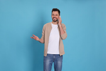 Man talking on phone against light blue background