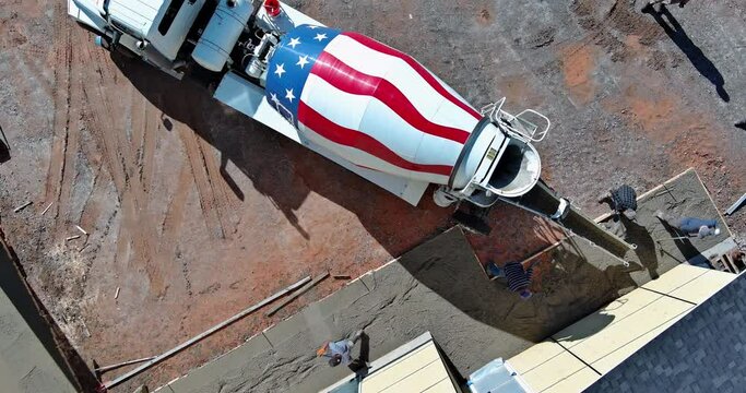 An concrete mixing truck pour out concrete for pavement around new house
