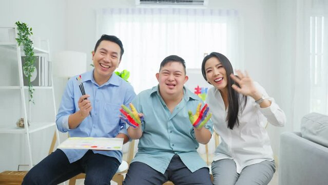 Portrait of Asian happy family, parents draw picture with young son.