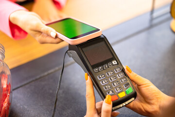 POS terminal, Payment Machine with mobile phone on store background. Contactless payment with NFC...