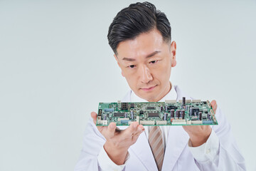 電子回路を持つ白衣を着た男性