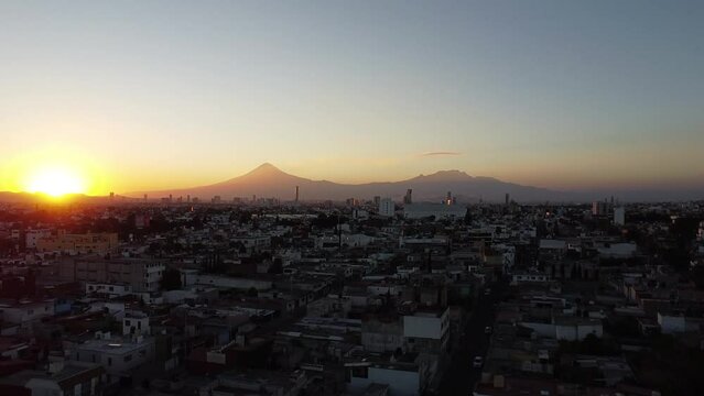 sunset in the city with volcanoes in the background, colors in the sky in the spring season in america, mexico, puebla 