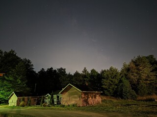 barn in the night with the sky full of stars in the wood of new hampshire in usa