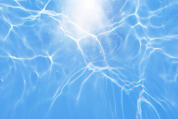 Defocus blurred transparent blue colored clear calm water surface texture with splashes and bubbles. Trendy abstract nature background. Water waves in sunlight with copy space. Blue watercolor shining