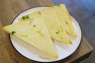 Three slices of toast cut into triangles lie in a white dish
