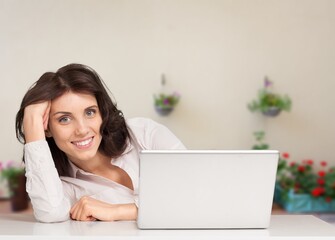 Young happy woman sitting with laptop computer