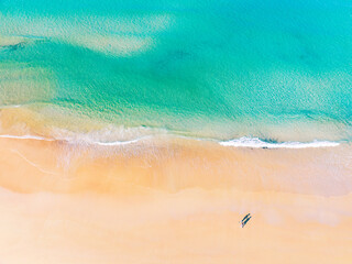 Aerial view of amazing beach with honeymoon couple walking on beach in morning light close to turquoise sea,Top view of summer beach landscape,Holiday Travel and tour concept