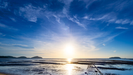 The sun's rays over the sea beautiful clouds with the setting sun over the sea,clear sea horizon over blue sky with sun shine,Nature environment sky background