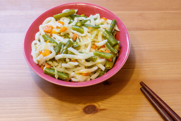 Udon noodles with vegetables on wooden table. Japanese cuisine. Asian food