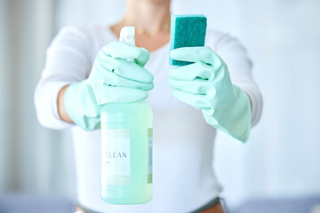 Woman, hands and detergent for housekeeping, cleaning or disinfect with latex gloves in sanitary home. Hand of female cleaner holding sanitizer bottle and sponge for domestic work or clean hygiene