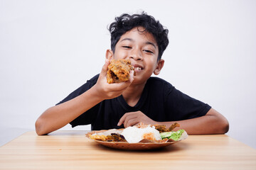 Little Boy eating Fried Fish and rice at home