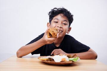 Little Boy eating Fried Fish and rice at home