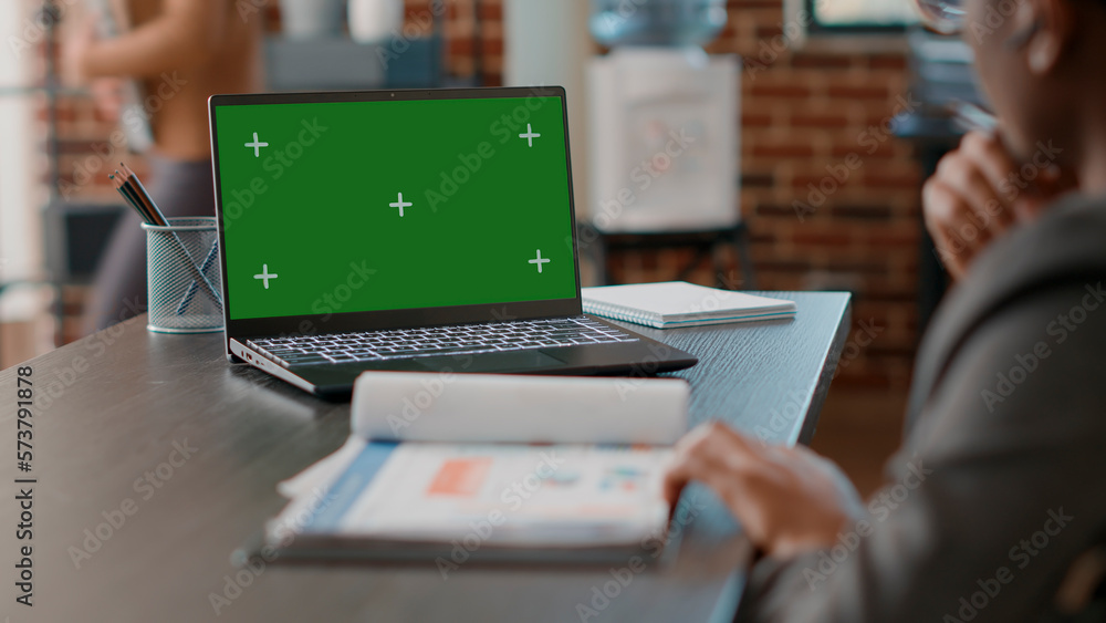 Poster man using greenscreen on laptop and taking notes at office job. business employee working with mocku