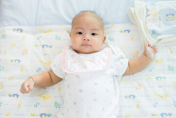 Portrait of a newborn Asian baby on the bed