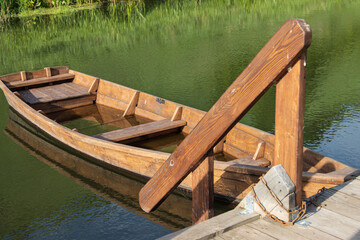 Naklejka premium wooden boat near the river