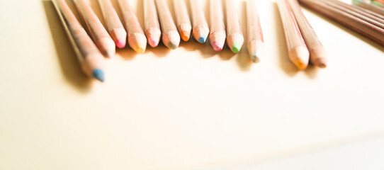 Layout of pastel pencils with space for text. Pastel pencils in a wooden case. Horizontal format