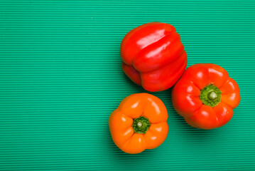 Group of bell peppers of different colors on green background. Bell peppers of different colors.
