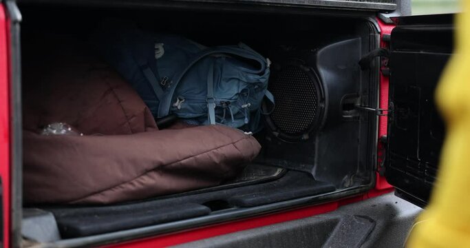 Driver tourist traveler takes out backpack from car