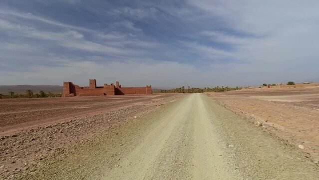 Passing next to an old kasbah on a dirt road. Draa Valley in Morocco