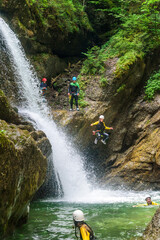 Mutiger Sprung ins schäumende Wasser eines Gebirgsbachs beim Canyoning
