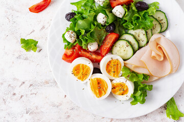 Ketogenic diet. Boiled eggs, ham, mozzarella cheese and fresh salad.  Keto breakfast. Brunch.  Top view, overhead