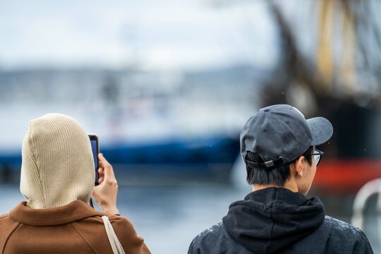 people taking photos with their phone of tall ships at a festival in tasmania australia. wooden boat festival. exciting event.