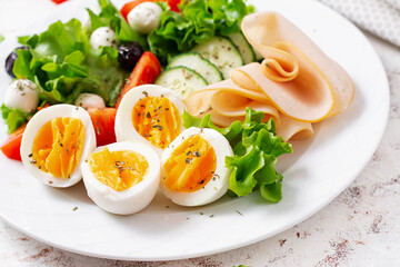 Ketogenic diet. Boiled eggs, ham, mozzarella cheese and fresh salad.  Keto breakfast. Brunch.