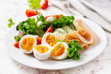 Ketogenic diet. Boiled eggs, ham, mozzarella cheese and fresh salad.  Keto breakfast. Brunch.