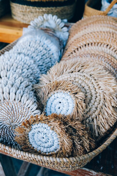 different handmade coasters round with shells for home decoration in craft shop.