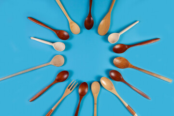 Wooden kitchen utensils, tools and equipment on blue background.