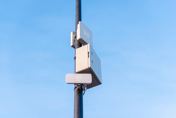 Light and wireless network on the pole with blue sky background.Telecommunications equpiment on a pole.Copy space.