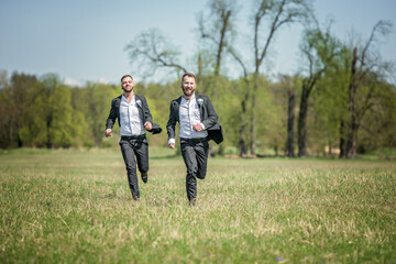 Two newlyweds running through a meadow. A gay couple. Gay partners had a wedding.
