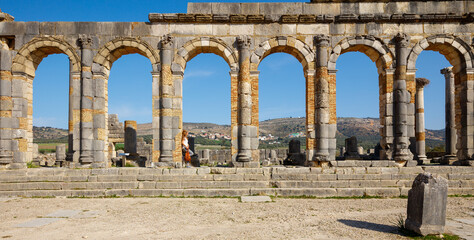 Fototapeta premium Woman tourist enjoying beautiful Volubilis site in Morocco, Meknes province