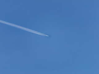 Fototapeta na wymiar Photo of a plane leaving trails in the clear blue sky
